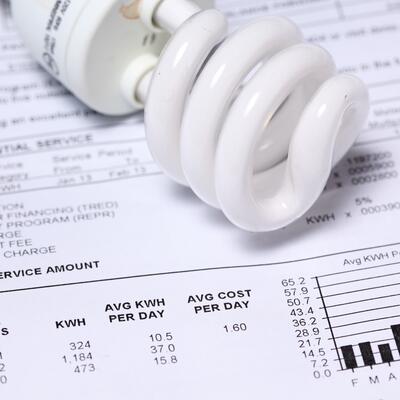 A CFL lightbulb placed atop a utility bill