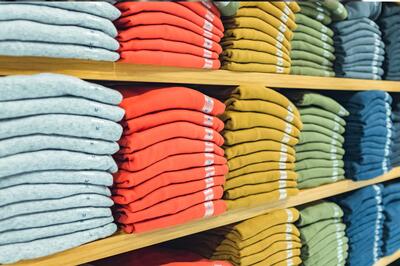 Folded shirts line a store's shelves